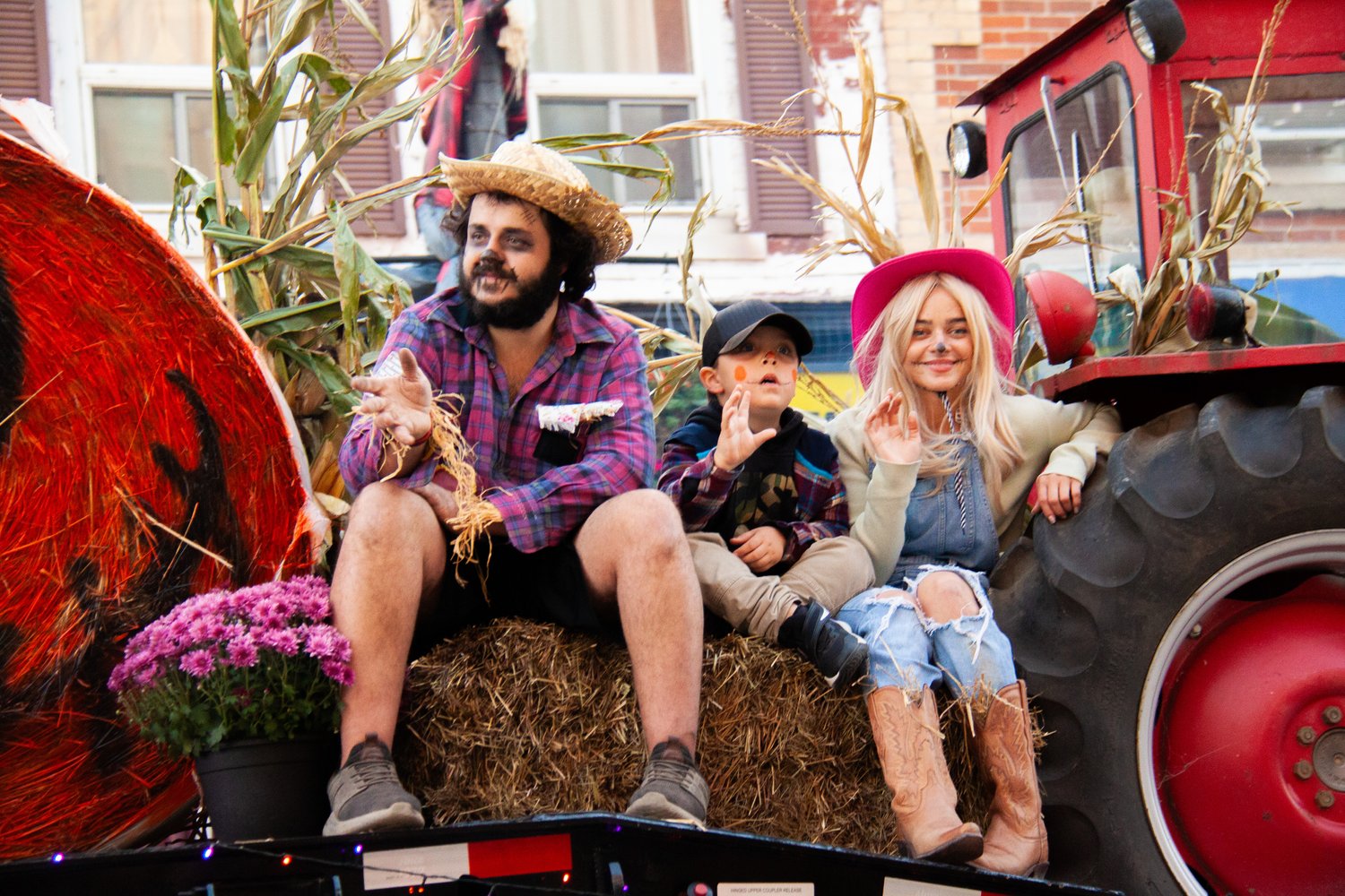 Three people dressed as scarecrows ride on a float.