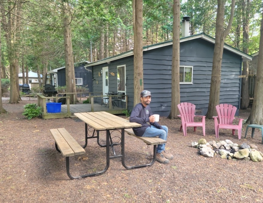 Exterior view of cottage with picnic table summer