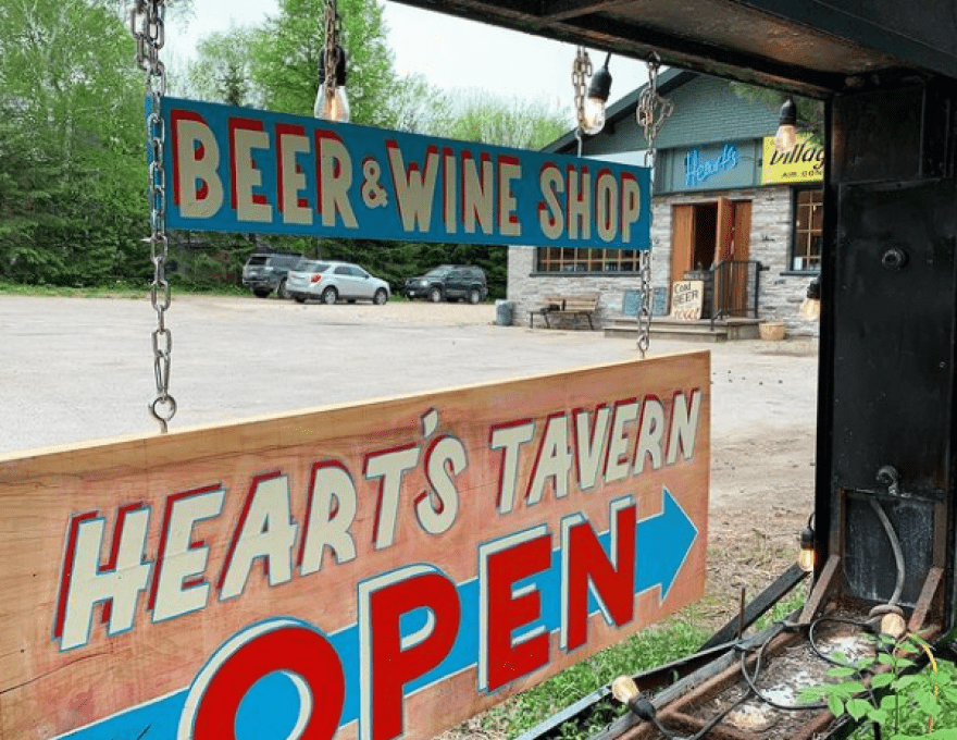 Photo of parking lot and Hearts Tavern Open Sign
