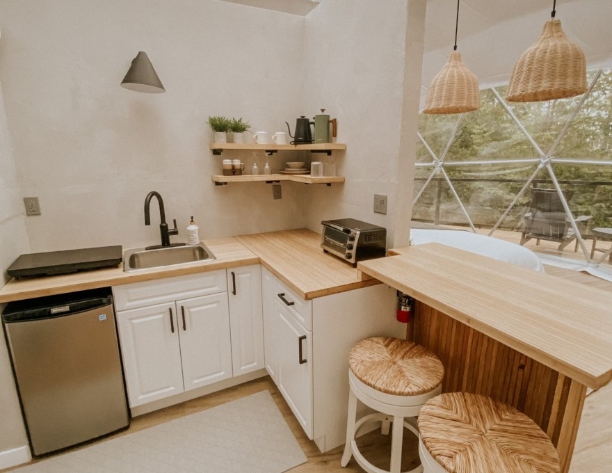 full kitchen with electric stove top, mini fridge, toaster oven, kettle and coffee press