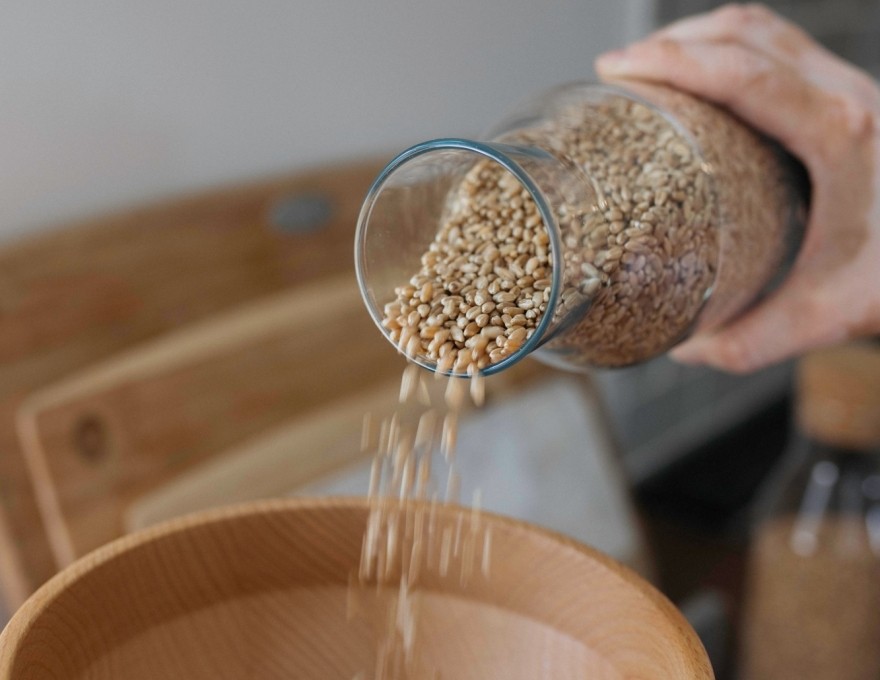 picture of grains being poured into wooden bowl