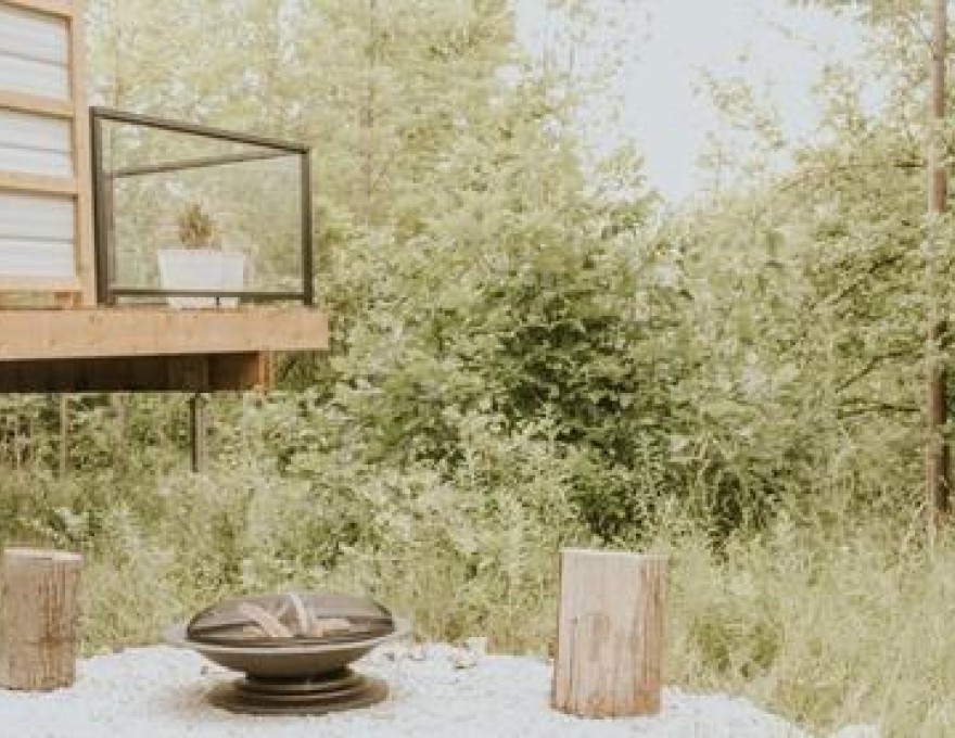 private porch with a BBQ, chairs and hotub looking out to the forest.