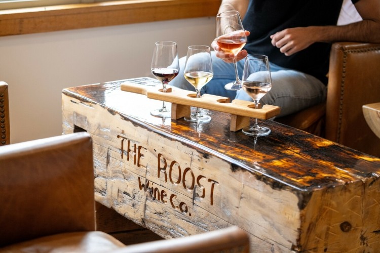 A man sitting at a table with a flight of wines