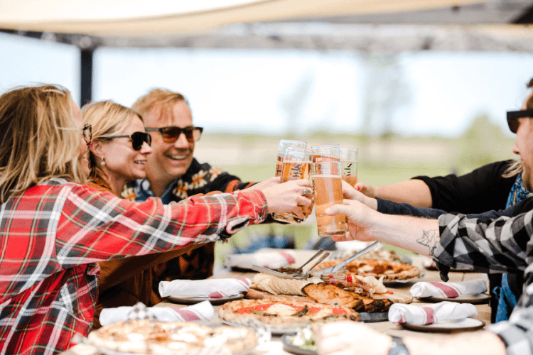 A group of people raising a toast with Spy Cider