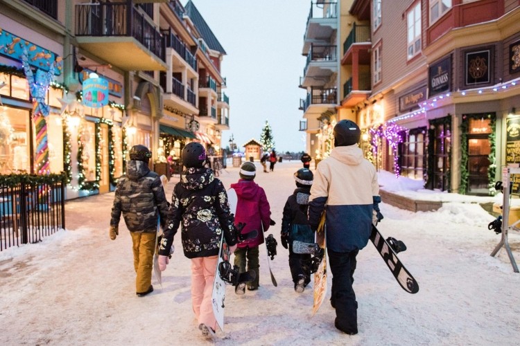 Blue Mountain Resort kids walking with their parent holding skis
