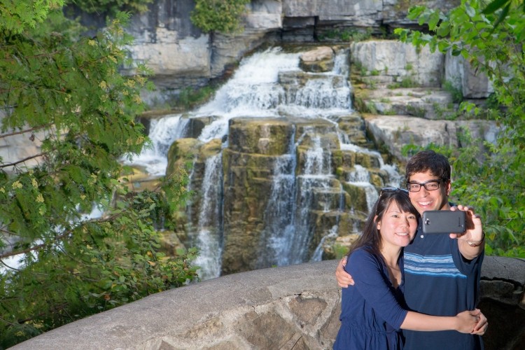 Inglis Falls A couple taking a photo in front of a waterfall
