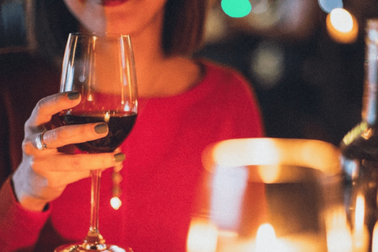 Sweetwater Restaurant  A woman holding a wine glass with red wine