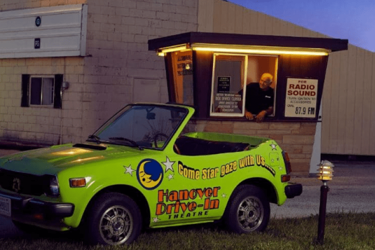 a branded car parked in front of a ticket booth