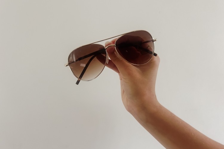 Someone holding sunglasses