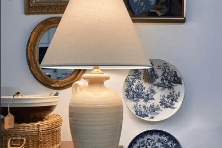 A lamp sitting on a side table with other decor around it.