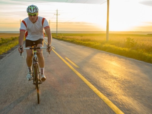 Cyclist on road at sunset