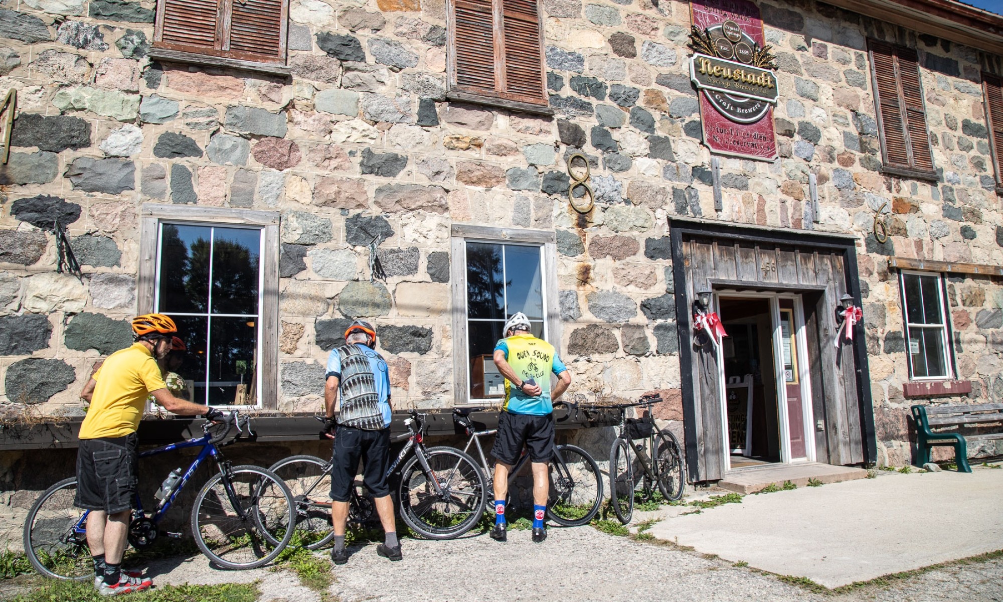 Neustadt Springs Brewery Cyclists in front of stone building