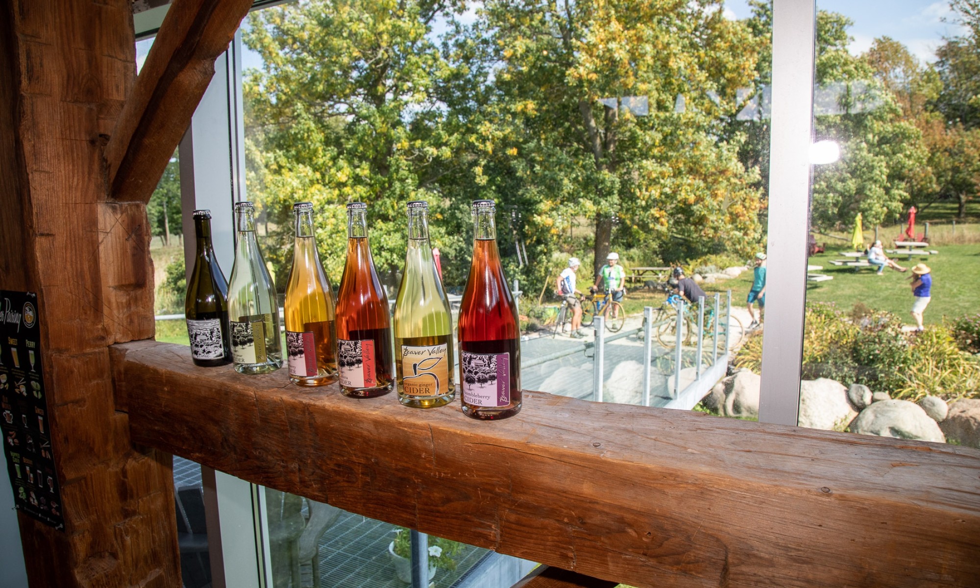 Cider bottles lined up on barn beam