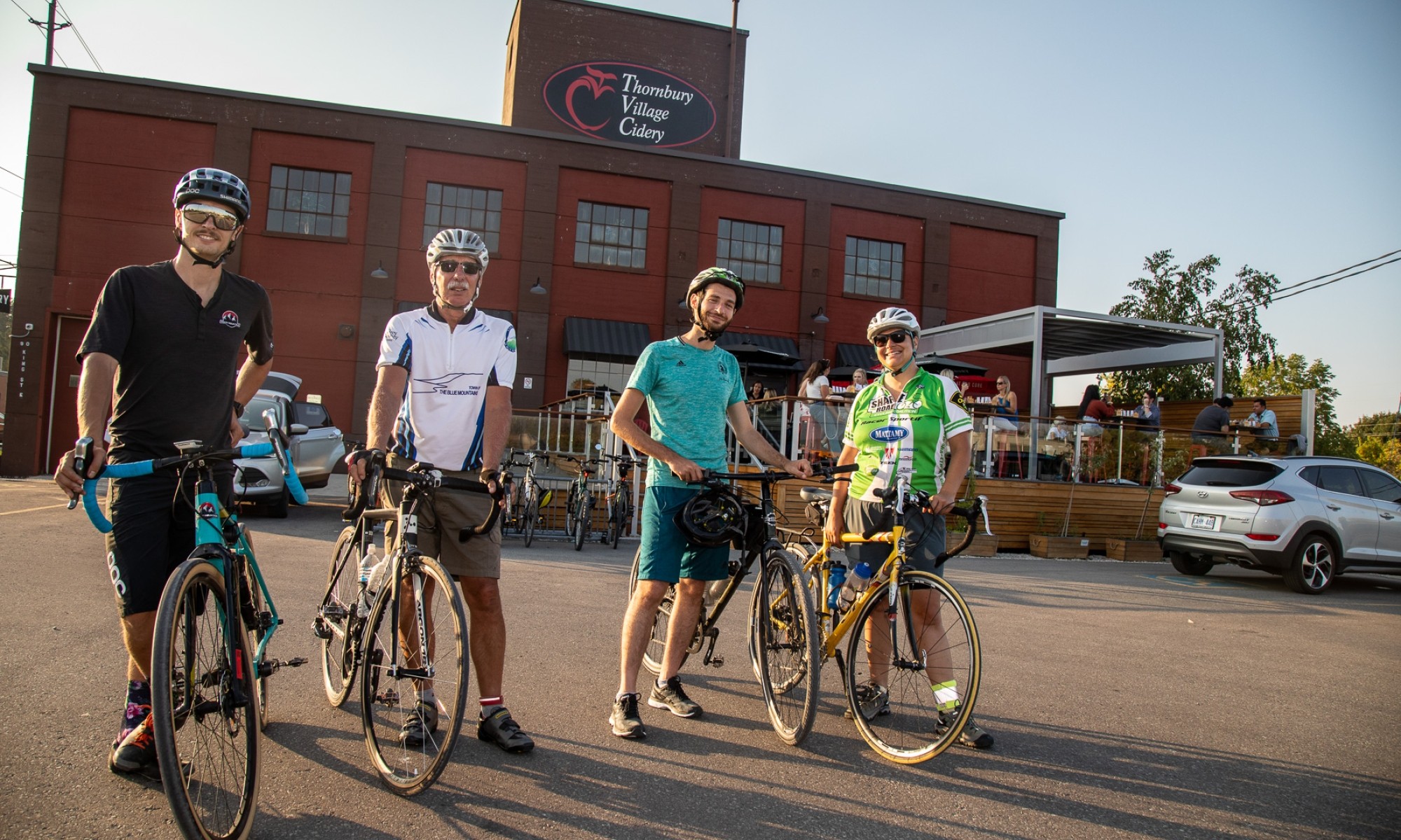 Four cyclists standing in front of Thornbury Cider House