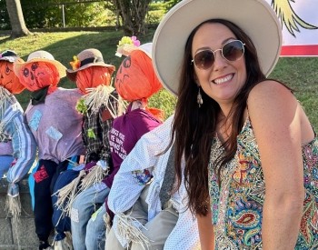 a woman sitting with scare crows 